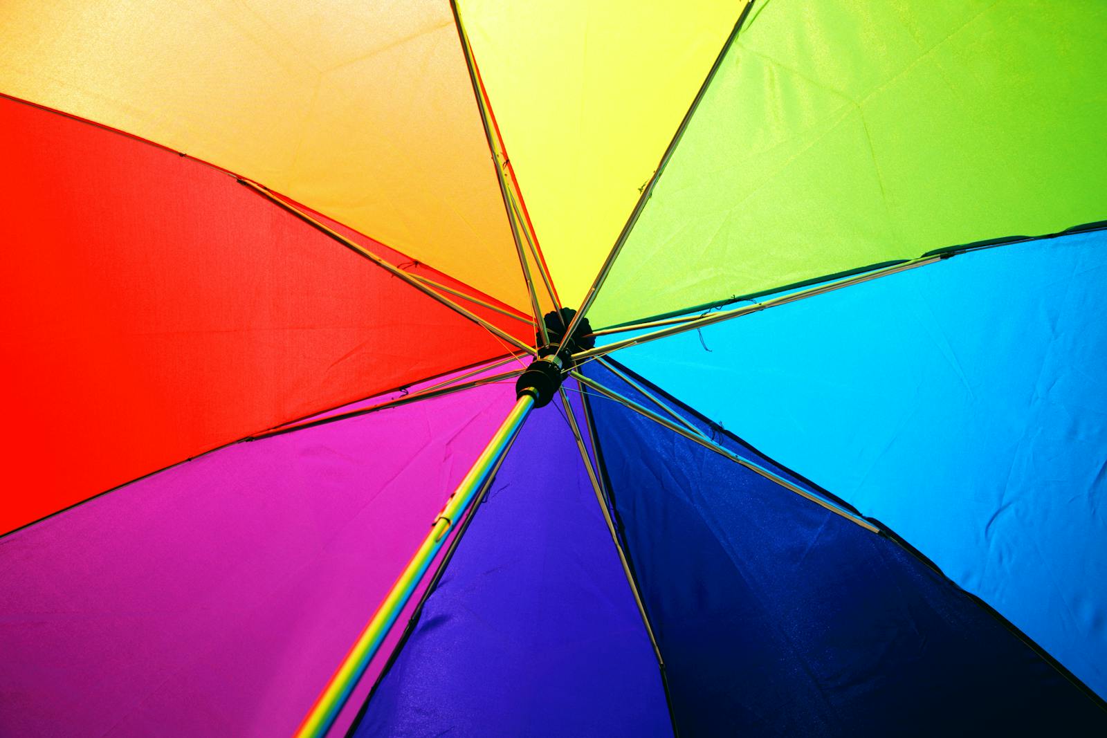 A close-up of a colorful rainbow umbrella showcasing vivid multicolored panels.